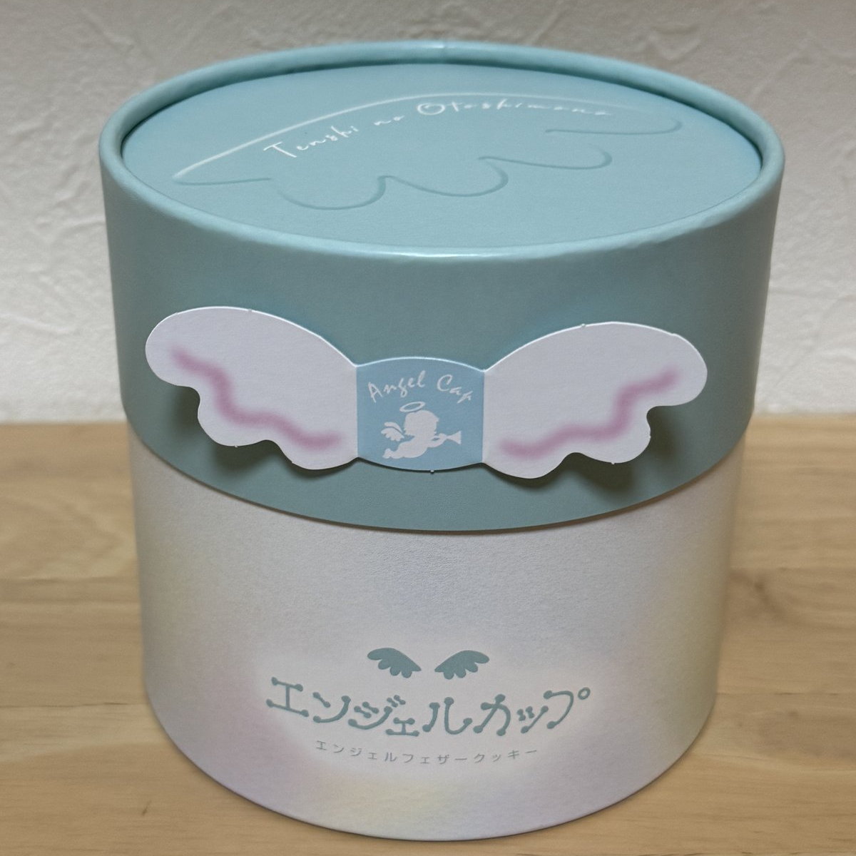 エンジェルカップの筒型の箱。水色の蓋に天使の羽の飾り